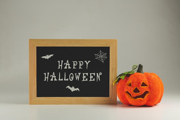 Feliz Halloween escrito em um quadro e falsa abóbora curva - fundo de Halloween