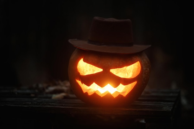 Feliz Halloween Espeluznante Jack o linterna brillante en hojas de otoño en un bosque oscuro de mal humor Calabaza tallada de Halloween atmosférica aterradora en el bosque de otoño de la tarde Tiempo de terror de Boo Espacio de copia