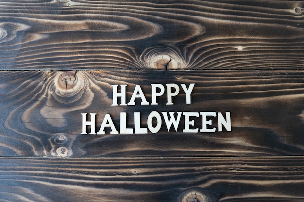 Foto feliz halloween letras sobre fondo de madera