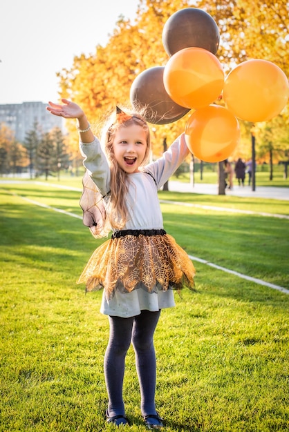 Feliz Halloween Linda brujita con una bola de aire niña pequeña disfrazada de bruja al aire libre