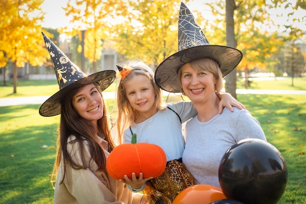 Feliz halloween mãe avó e filha estão se divertindo na festa de outono balões de abóbora laranja