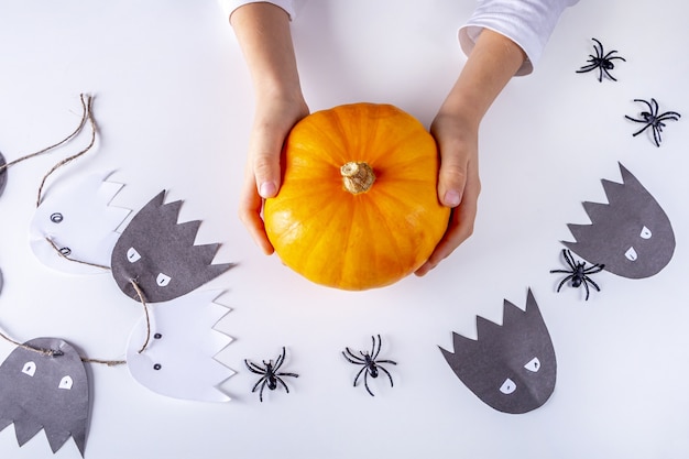 Feliz Halloween. Mano de niño sosteniendo calabaza pequeña