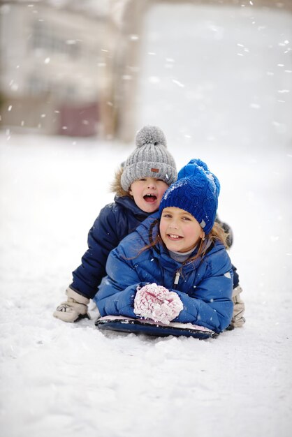 Feliz hermano y hermana jugando en la nieve