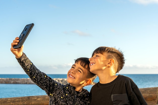 Feliz hermano tomando selfie cerca del mar