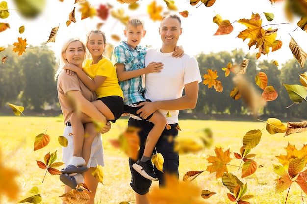 feliz hermosa familia de cinco en un paseo en otoño contra el fondo de hojas amarillas.