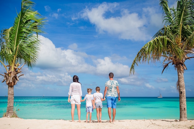 Foto feliz hermosa familia de cuatro en la playa