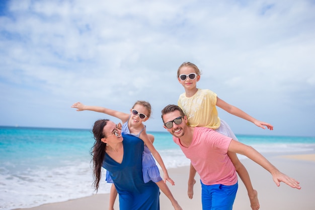 Feliz hermosa familia de cuatro en la playa