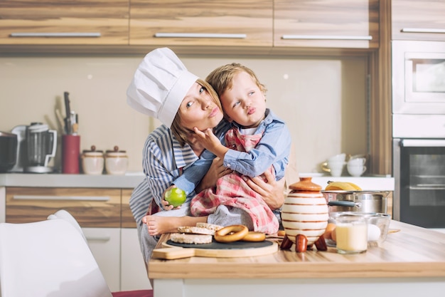 Feliz y hermosa familia madre e hijo juntos en la cocina cocinando