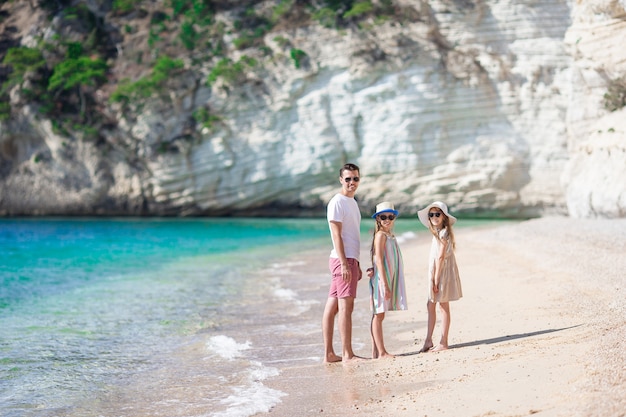 Foto feliz hermosa familia de papá e hijos en la playa blanca