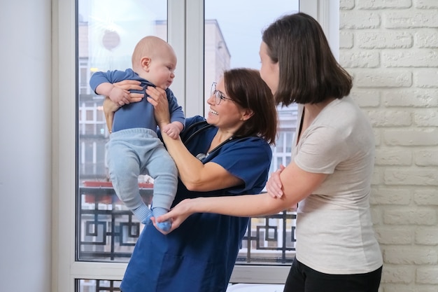 Feliz hermosa joven madre jugando con su hijo pequeño