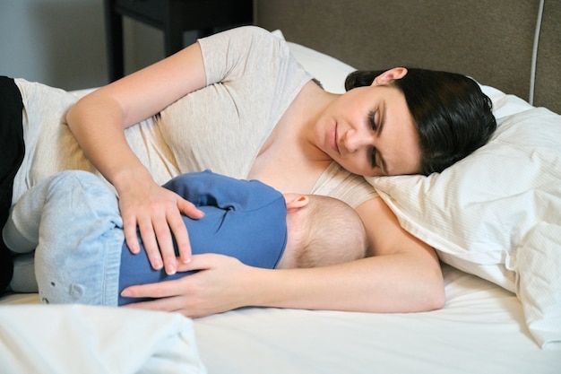 Feliz hermosa joven madre jugando con su hijo pequeño