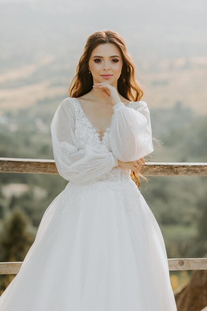 Feliz hermosa joven novia afuera en un prado de verano al atardecer