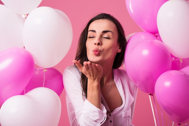 Feliz hermosa linda mujer encantadora con globos de colores y regalo en las manos es divertirse y celebrar. Cumpleaños, vacaciones, día de San Valentín y otros