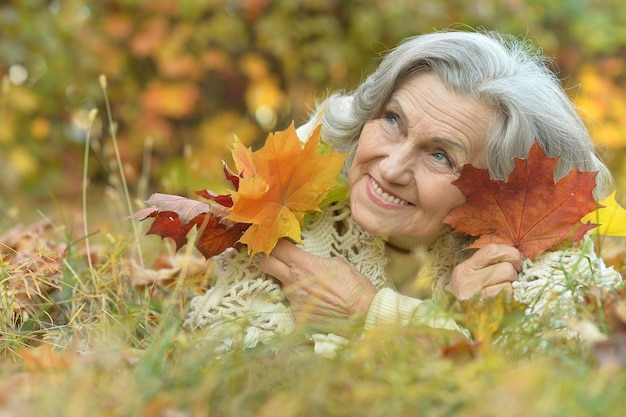 Feliz hermosa mujer mayor en el parque otoño