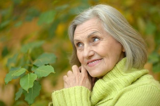 Feliz hermosa mujer mayor en el parque otoño