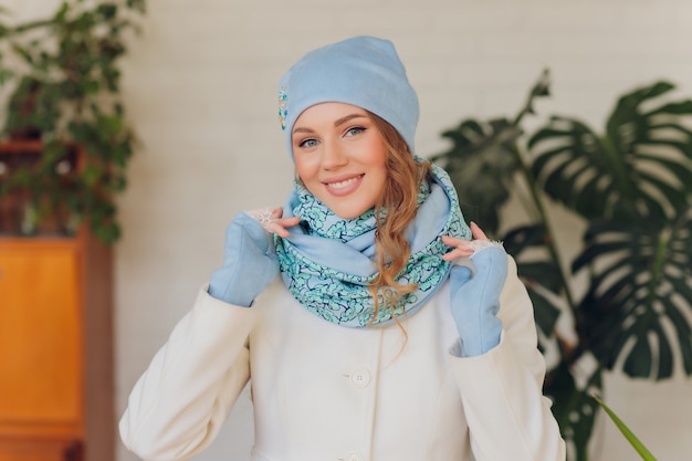 Feliz hermosa mujer mirando hacia los lados con entusiasmo. chica con guantes y gorro de punto.