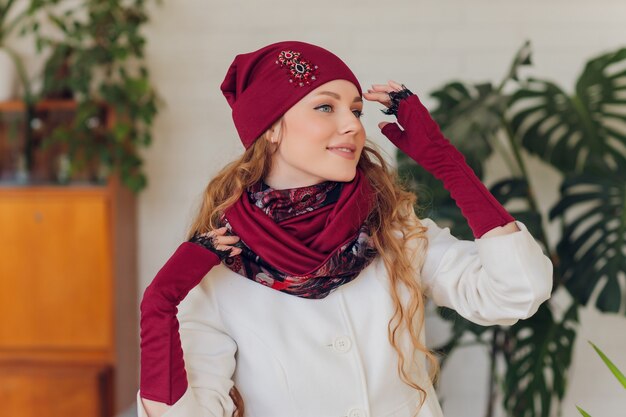 Feliz hermosa mujer mirando hacia los lados con entusiasmo. chica con guantes y gorro de punto.