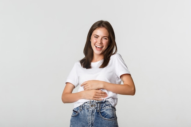 Foto feliz hermosa mujer riendo de algo divertido.