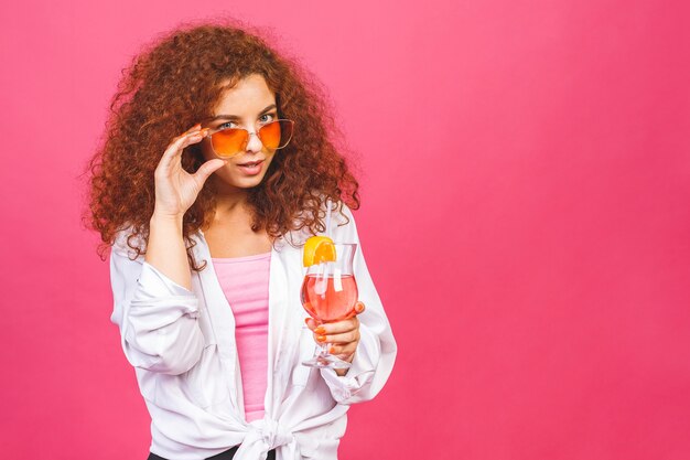 Feliz hermosa mujer en ropa casual de verano con una copa de cóctel tiro de estudio