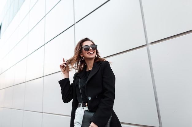 Feliz hermosa mujer con sonrisa en ropa de moda negro