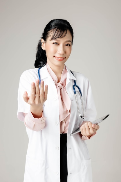 Feliz hermosa mujer trabajadora asiática en ropa de oficina sonriendo y sobre fondo gris aislado