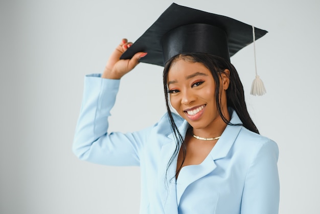 Feliz hermosa niña afroamericana negra con graduados de sombrero