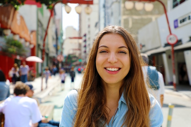 Feliz hermosa niña sonriente caminando en el barrio japonés de Sao Paulo Liberdade, Sao Paulo, Brasil.