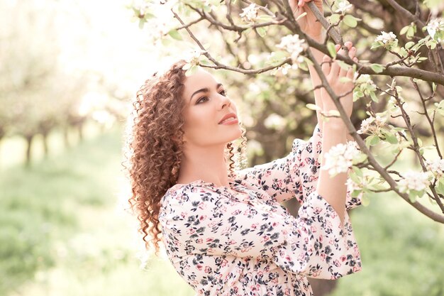 Feliz hermosa niña sosteniendo flores al aire libre