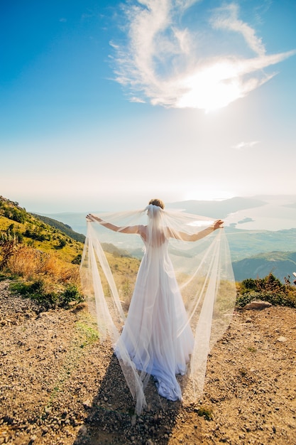 Feliz hermosa novia al aire libre vestido de novia ondeando