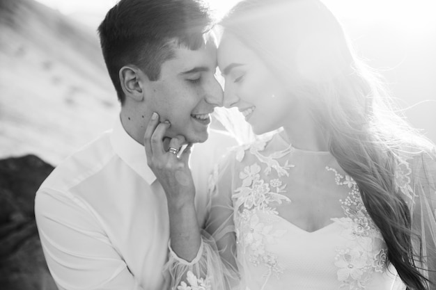 Feliz hermosa pareja de novios novia y novio en el día de la boda al aire libre en la roca de las montañas.