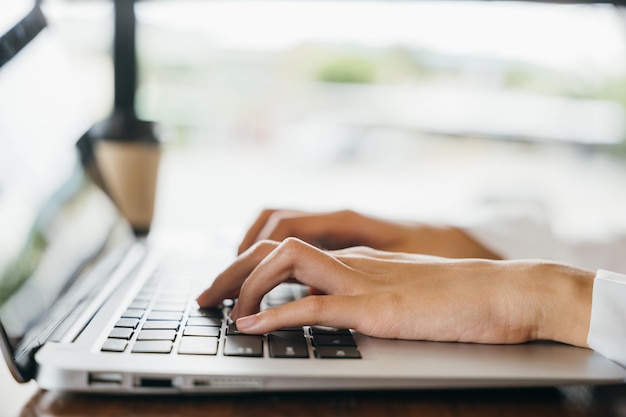 Feliz hermoso blogger independiente escribiendo teclado en la computadora portátil para escribir la página web del blog