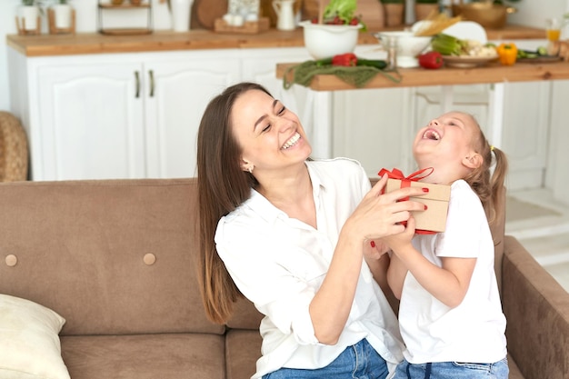 Feliz hija y madre se regocijan con el regalo y se ríen juntas