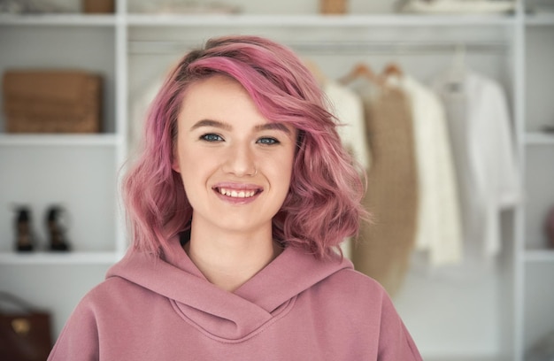Feliz hipster gen z jovencita diseñadora de moda con retrato de cabello rosado en la cabeza