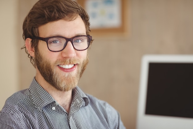 Feliz hipster sentado em sua mesa