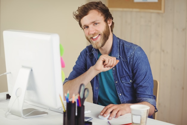 Feliz hipster trabalhando em sua mesa