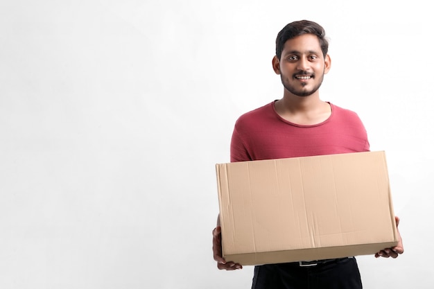 Feliz hombre asiático en camiseta y gorra con caja vacía aislada sobre fondo blanco, concepto de servicio de entrega