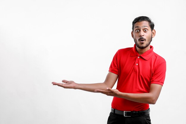 Feliz hombre asiático en camiseta y mostrando expresión aislada sobre fondo blanco.