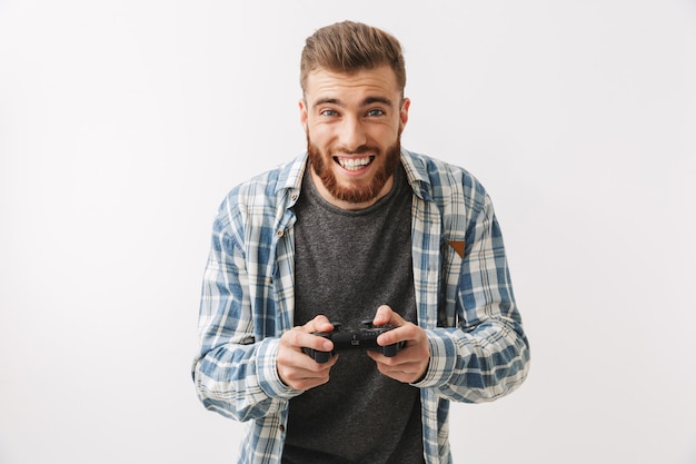 Feliz hombre barbudo en camisa jugando videojuegos con joystick