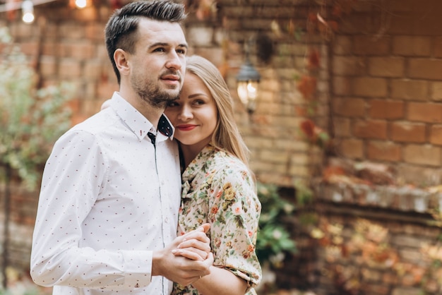 Feliz hombre y mujer enamorados que datan en la calle de otoño. Feliz pareja de dos abrazándose durante el día acogedor en el parque. Concepto de estilo de vida