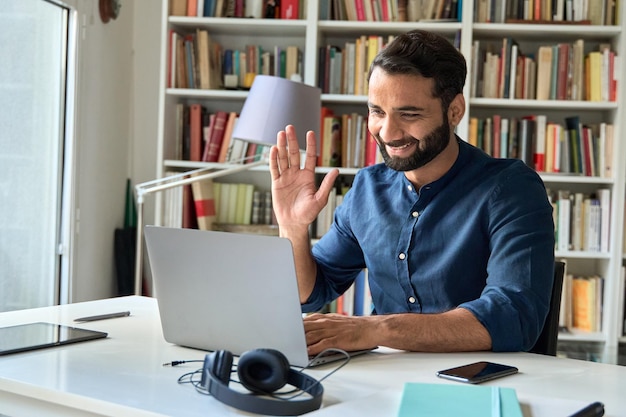 Foto feliz hombre de negocios indio maestro trabajando a distancia por videollamada reunión híbrida