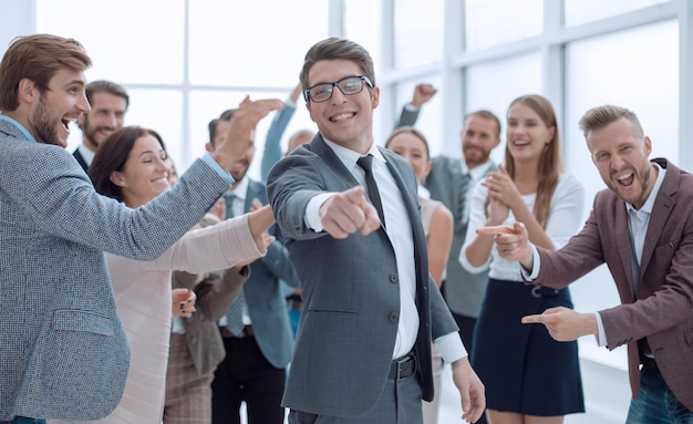 Feliz hombre de negocios de pie frente al equipo de negocios y poi