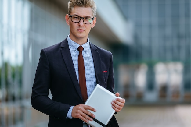 Feliz hombre de negocios sonriente con tableta digital. Concepto de tecnología moderna