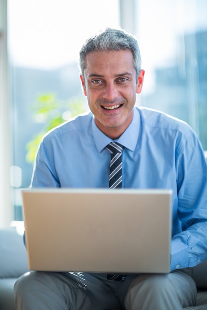 Foto feliz hombre de negocios usando la computadora portátil