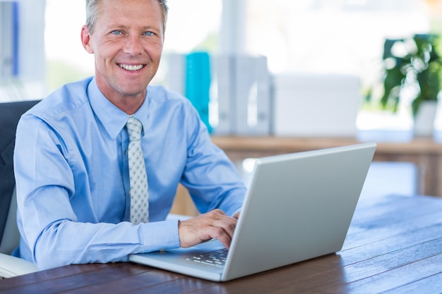 Feliz hombre de negocios usando la computadora portátil