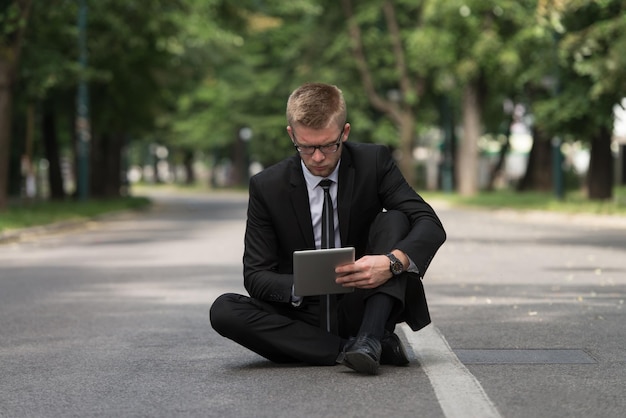 feliz, hombre de negocios, utilizar, tableta, pc, exterior, en, asfalto