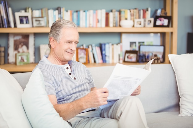 Feliz hombre senior leyendo periódico