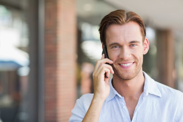 Un feliz hombre sonriente llamando