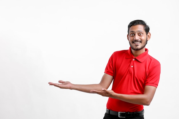 Feliz homem asiático em t-shirt e apresentando expressão isolada sobre fundo branco.