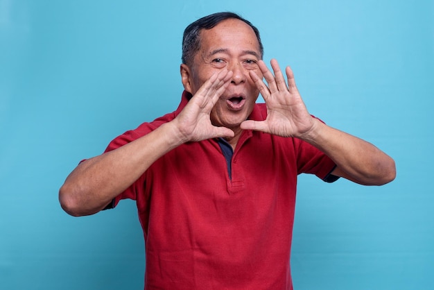 Feliz homem asiático idoso gritando e anunciando algo com expressão facial animada