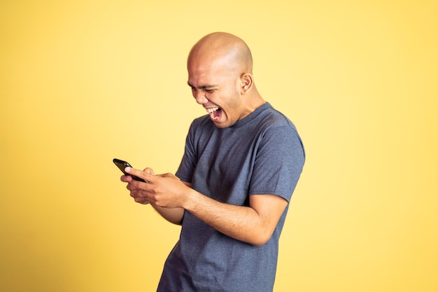 Feliz homem careca asiático olhando para um telefone celular